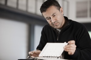 Hispanic businessman writing in notebook